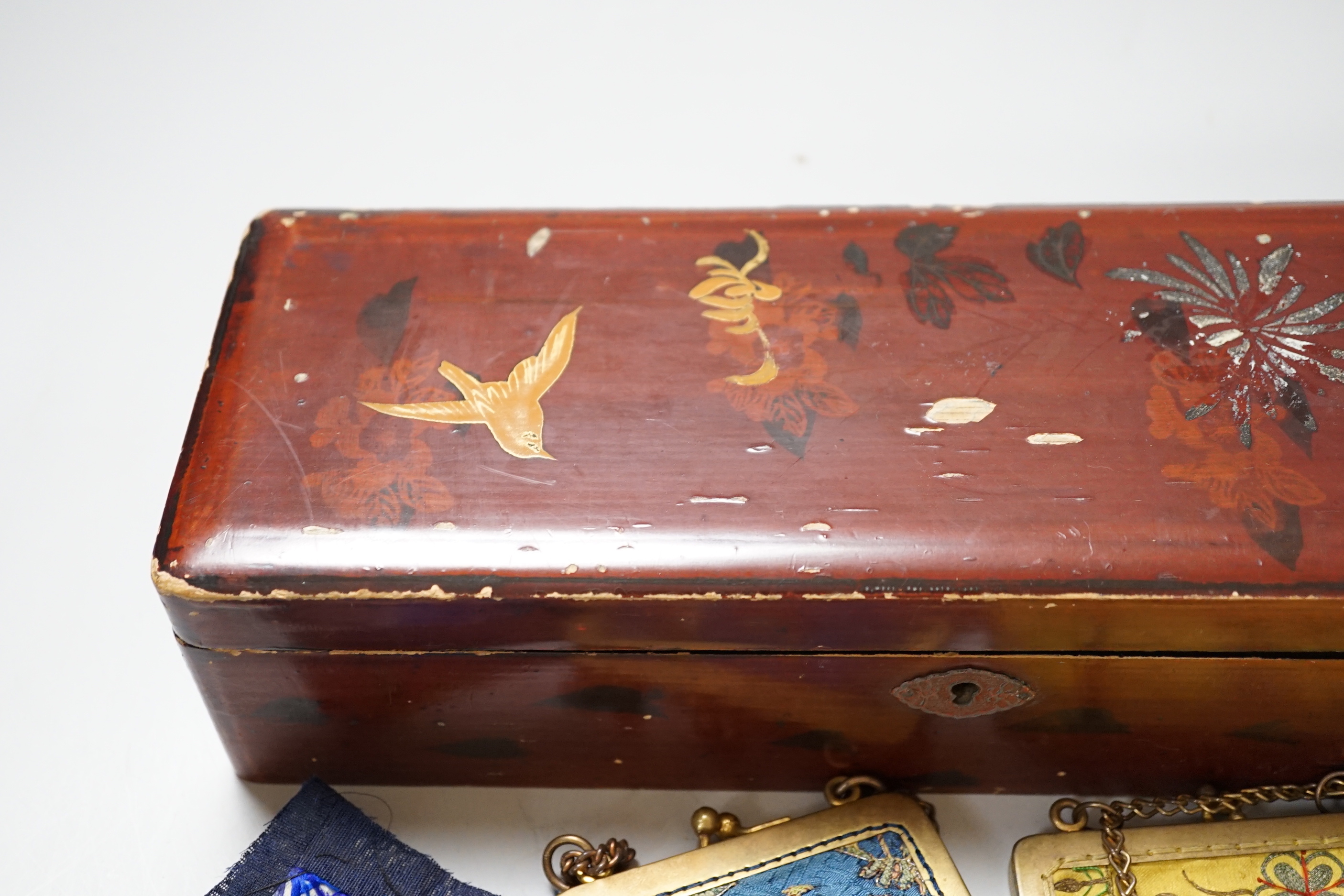A lacquer box of Chinese embroidered purses and embroideries.